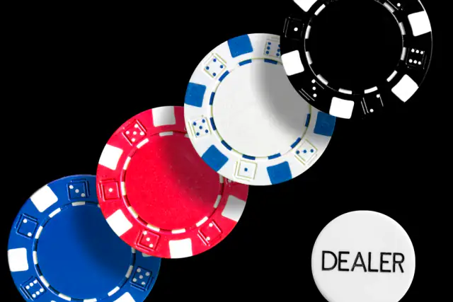 Blue, red, white and black chips beside a dealer button