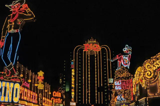 Neon casino signs glowing on a street at night