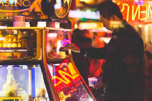 Player at a bank of brightly lit slot machines