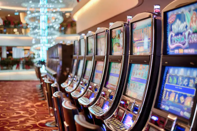 A long row of video slot cabinets inside a resort casino